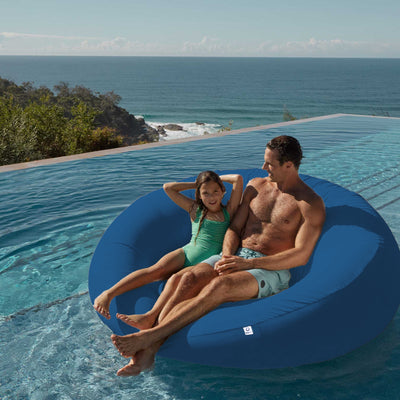 Pouf extérieur flottant en tissu Olefin bleu pétrole, dimensions 140x120 cm, avec pompe incluse, pour piscine ou jardin.