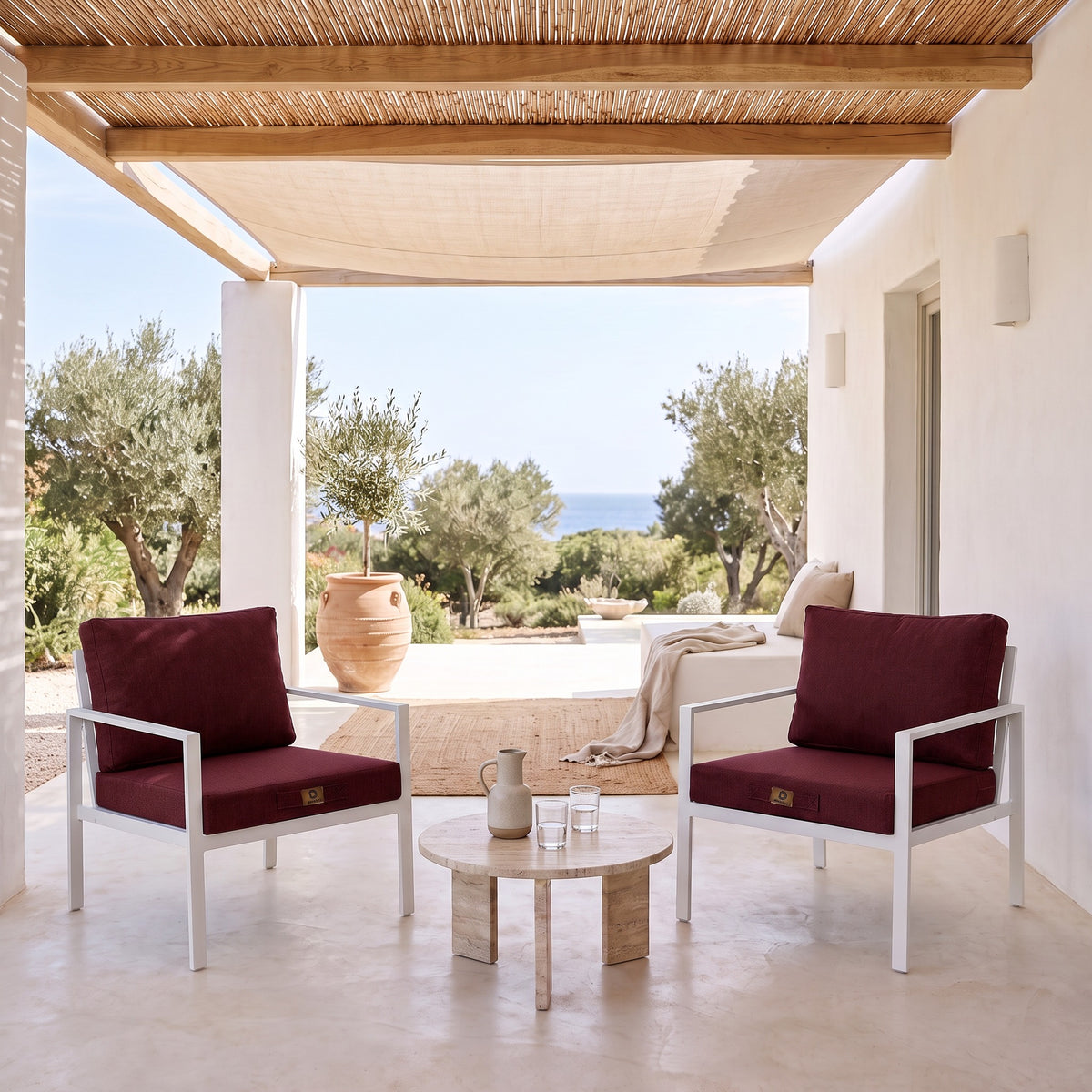 Cuscini per poltrona effetto lino Prugna su due poltrone bianche sotto una pergola coperta, terrazza luminosa al riparo dal sole