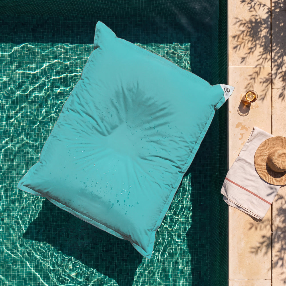 Pouf galleggiante gigante Blu Caraibi sull'acqua di una piscina, vista dall'alto