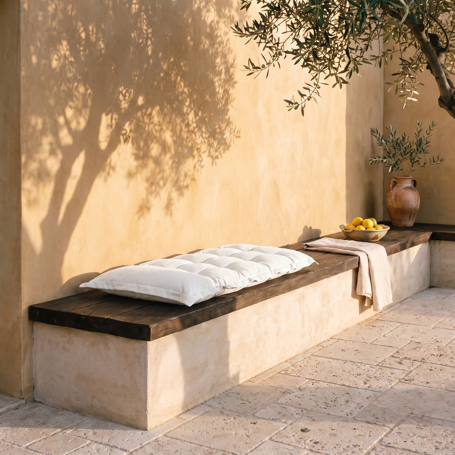 Cuscino trapuntato per panca e pavimento 120x60 Bianco Sporco su una panca in pietra, cortile mediterraneo