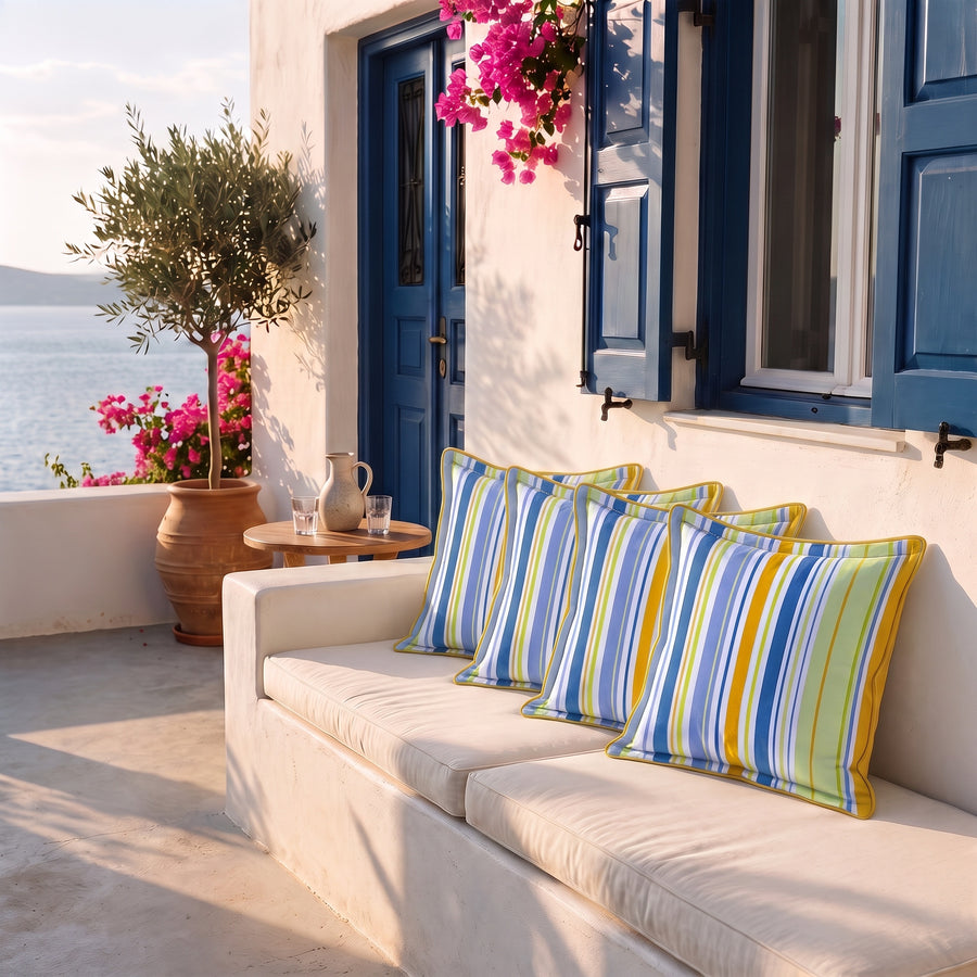 Set di 4 cuscini decorativi 45x45 motivo Righe Solari su una panca in terrazza vista mare