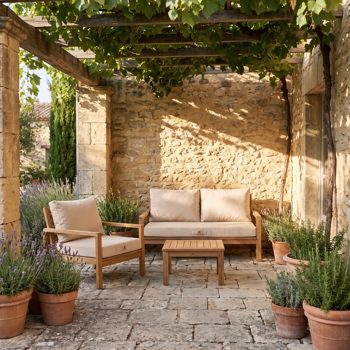 Fauteuil et banquette en teck avec coussins déhoussables beige Deco Arts sous une pergola de vigne