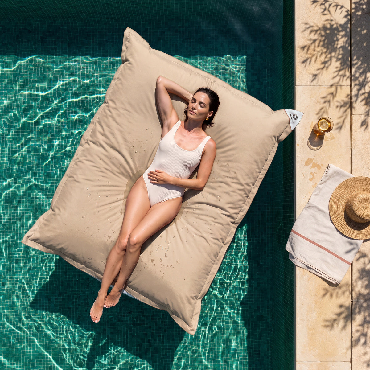 Solo fodera, da riempire – Pouf galleggiante gigante 180 × 140 cm Beige in piscina, donna sdraiata al sole, vista dall'alto