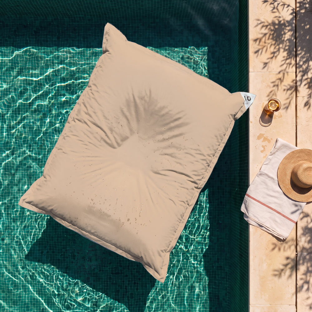 Solo fodera, da riempire – Pouf galleggiante gigante Beige sull'acqua di una piscina, vista dall'alto