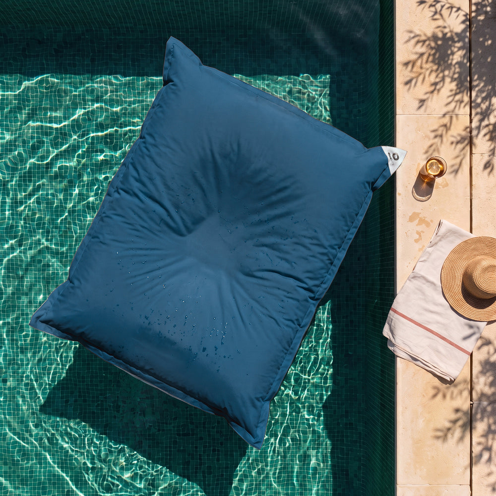 Solo fodera, da riempire – Pouf galleggiante gigante Blu Petrolio sull'acqua di una piscina, vista dall'alto