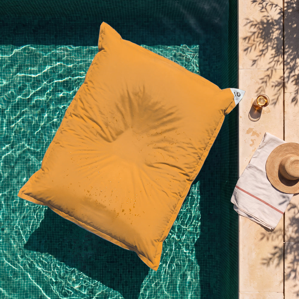 Solo fodera, da riempire – Pouf galleggiante gigante Giallo Miele sull'acqua di una piscina, vista dall'alto