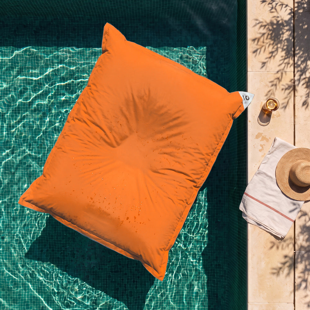 Solo fodera, da riempire – Pouf galleggiante gigante Arancione sull'acqua di una piscina, vista dall'alto