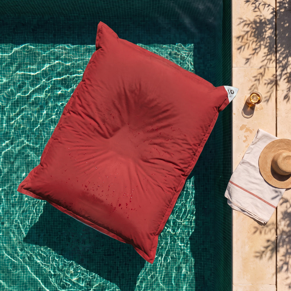 Solo fodera, da riempire – Pouf galleggiante gigante Rosso Peperoncino sull'acqua di una piscina, vista dall'alto